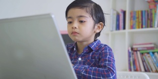 男孩在图书馆用笔记本电脑看视频
