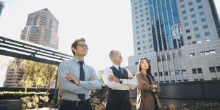 亚洲中国公司的首席执行官和他的团队在早上站在城市的办公大楼的屋顶交叉手臂望向别处