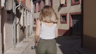 年轻女子在老街里奔跑，看着镜头视频素材模板下载