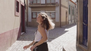 年轻的女游客在老街奔跑，回头看镜头视频素材模板下载
