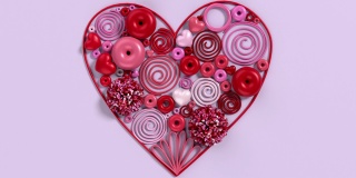 五颜六色的花，甜甜圈和糖果在粉红色的背景上创建心形在4K分辨率