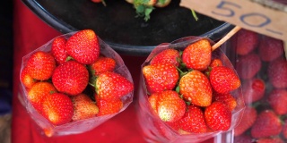 农贸市场上一袋袋新鲜的生态有机草莓的俯视图