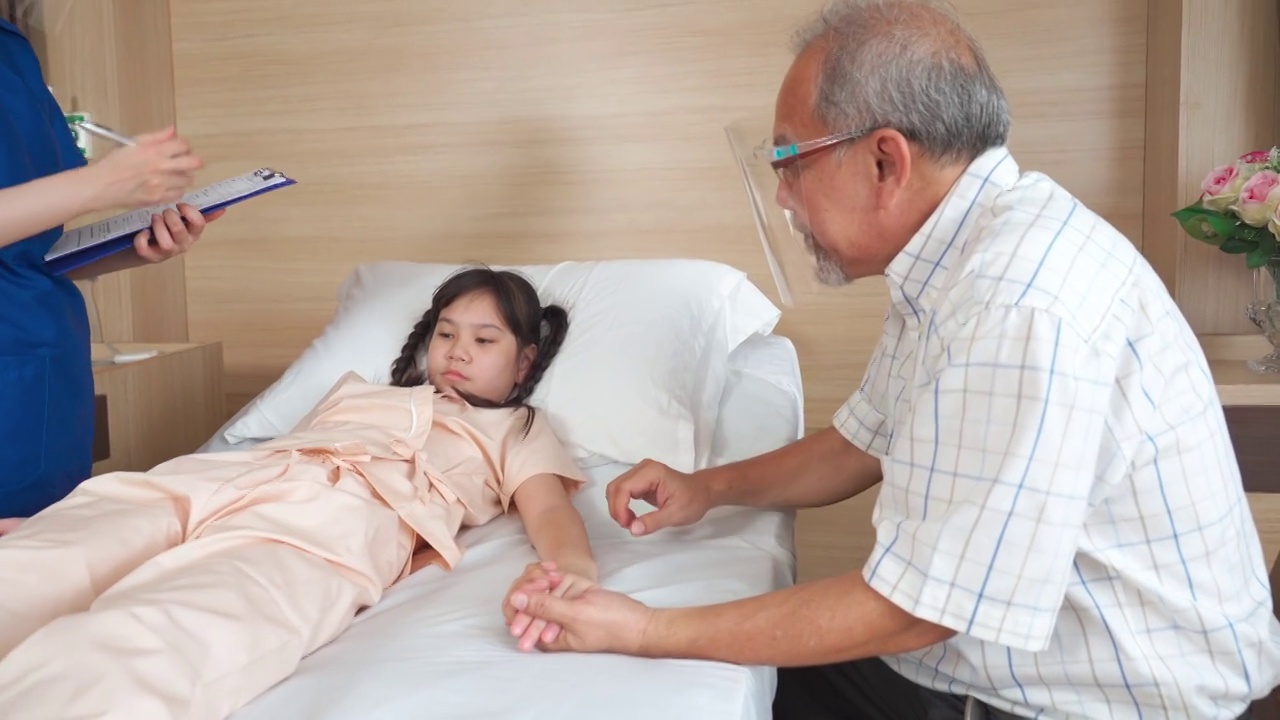 在医院的康复室里，父亲抚摸着女儿的手，安慰她