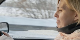 可爱的欧洲女人在一个冬天阳光明媚的日子里开车