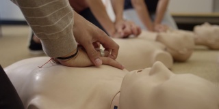 急救认证训练班在假人上练习胸部按压