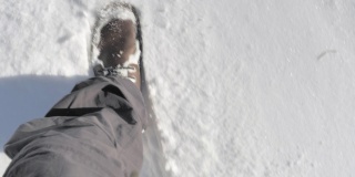 这是一个阳光明媚的日子里在雪地里行走的特写镜头。
