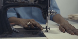 亚洲工人在印度工厂用老式缝纫机缝制纺织品