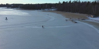 令人敬畏的无人机拍摄的人们在冰冻的海面上行走。
