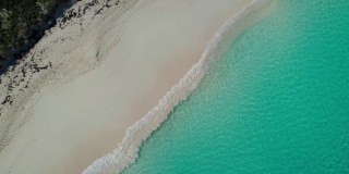 无人机航拍的沙滩海岸线与蓝绿色的海浪