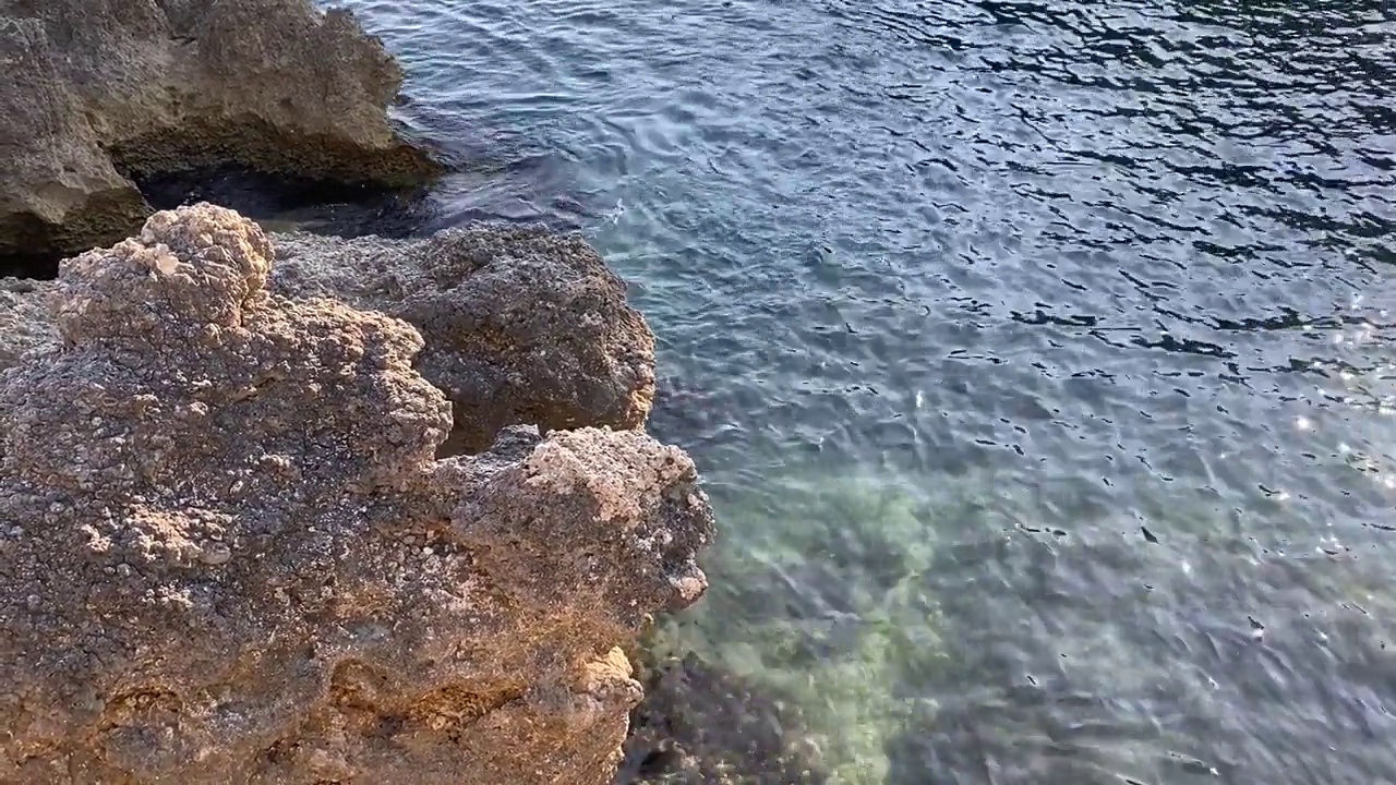 蓝绿色的海水波纹背景。透明的绿色海水表面在热带天堂泻湖。美丽的海景。地中海沿岸岩石嶙峋，海水平静。禅。放松。大自然。
