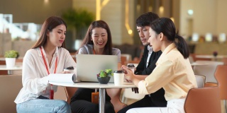 年轻的亚洲女性和商人正在办公室与同事们讨论。业务团队工作，与合作伙伴分享项目想法
