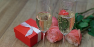 浪漫概念两个酒杯，红色心形礼盒，粉色玫瑰木制