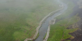 人们在乡村流淌的暖流中放松。沿着小溪的木板路，水雾缭绕。冰岛