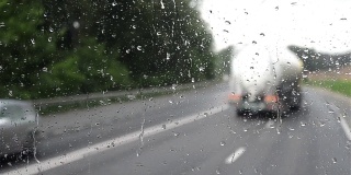 从卡车的挡风玻璃可以看到大量的车辆，其中有许多溅起的水