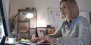 年轻女性晚上在家用笔记本电脑工作