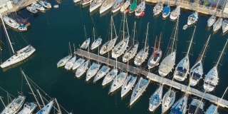 空中鸟瞰克罗地亚斯普利特海滩港口的亚得里亚海海岸。欧洲的傍晚初升，夏日的白天有小船和游艇在平静的水面上。码头停靠着小船，摩托艇在水面上漂浮。
