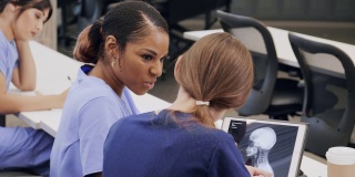 女医学生在数码平板电脑上检查x射线图像