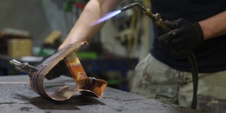 金属工艺师使用气焊炬进行金属加工。工人戴着防护手套在车间工作。做你自己。小生意。
