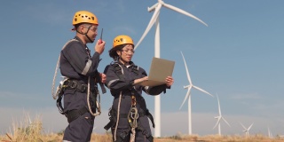 在泰国风电场，两名亚洲工程师在统一的检查工程师准备和进度检查风力发电机的安全。