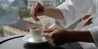 在香港中央金融区的一次商务旅行中，一名男子在酒店房间里搅拌咖啡