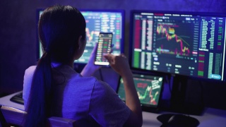 金融顾问亚洲女商人一边工作到深夜，一边分析和学习股票市场和加密货币图表视频素材模板下载