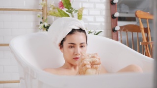 亚洲女性在浴室的浴缸里洗澡。视频素材模板下载