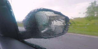 雨天的侧视汽车后视镜。高速运动。