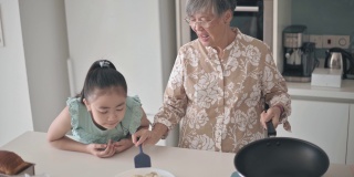 亚洲华人老太太和她的孙女在周末的空闲时间在厨房准备饺子