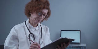 集中女医生放射科医生在登记簿上写文章，在诊所办公室工作。有资格的老年专业医生开药治疗疾病，处理文书工作