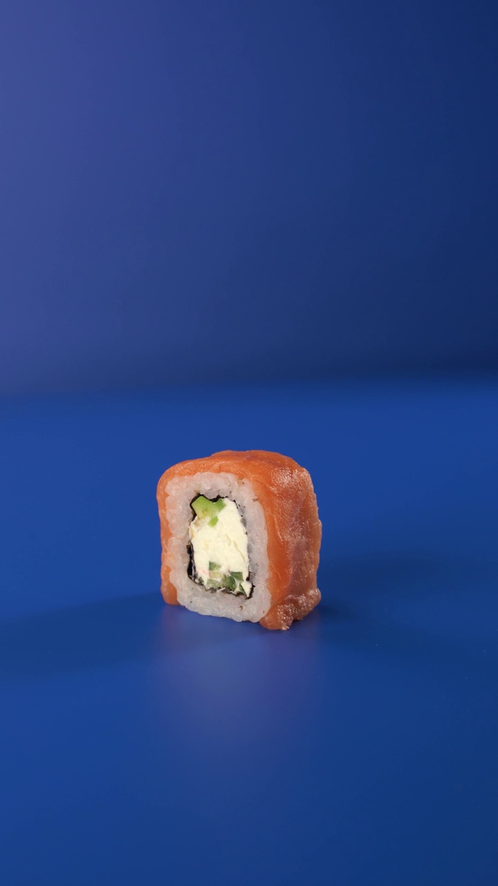 蓝色背景上的费城纺车。寿司4k垂直食物视频社交网络。