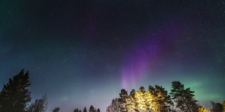 通过密集和快速移动的北极光，飞到星星上。晴朗的天空，明亮的星星，浅绿色和蓝色的北极光。北欧的冬季天气。瑞典