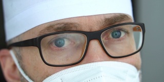 疲惫严重的成熟男性专业医生带着口罩、眼镜和防护服，接走了大量因冠状病毒疫情而感染的患者