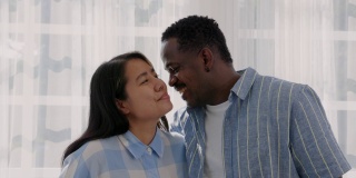 一个非裔美国人在家里亲吻妻子的前额。