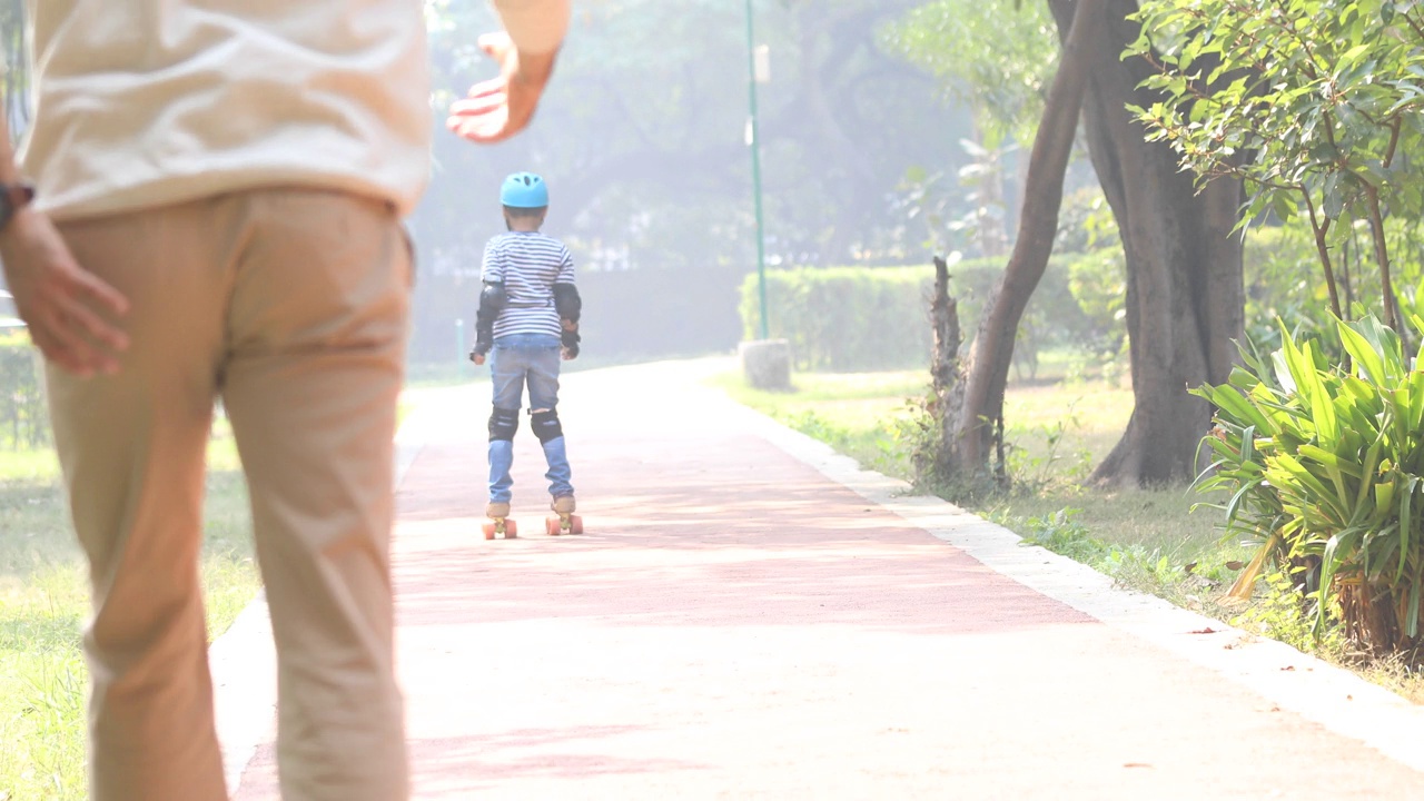 男孩在公园里学习轮滑