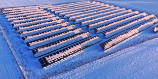 冬天的太阳电池板和风力涡轮机在日出。