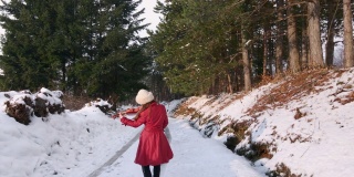 一个女人在冰冻的森林里的路上跳舞拉小提琴