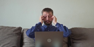 一个男人正在笔记本电脑上工作。压力、头痛、绝望