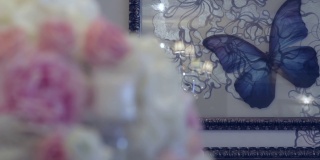 婚礼装饰进入大厅，墙上的蝴蝶和巨大的玫瑰花束，放在桌子上