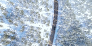 汽车行驶在遥远的雪原林间道路上