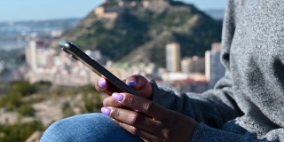 黑人女性在智能手机屏幕上滚动信息