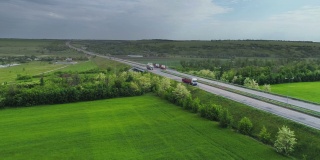卡车沿着绿色田野附近的道路行驶。油罐车在高速公路上行驶。卡车在高速公路上行驶