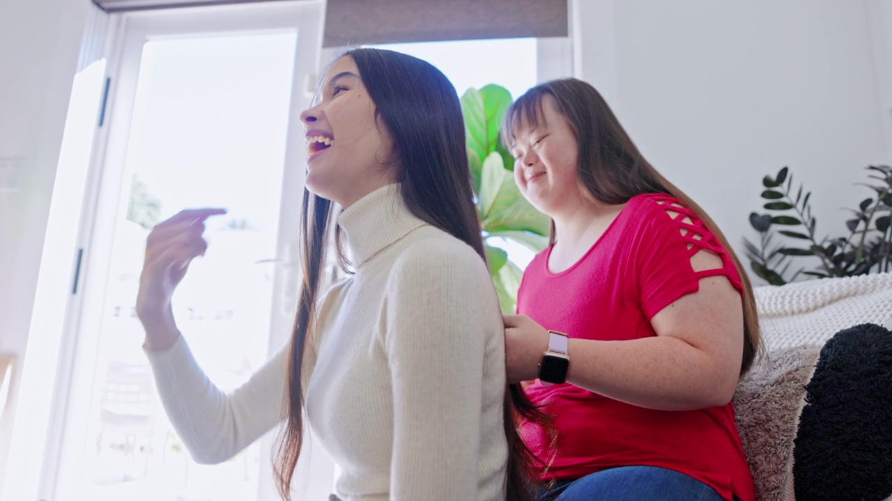 不同的姐妹为彼此做头发。一个女孩患有唐氏综合症。