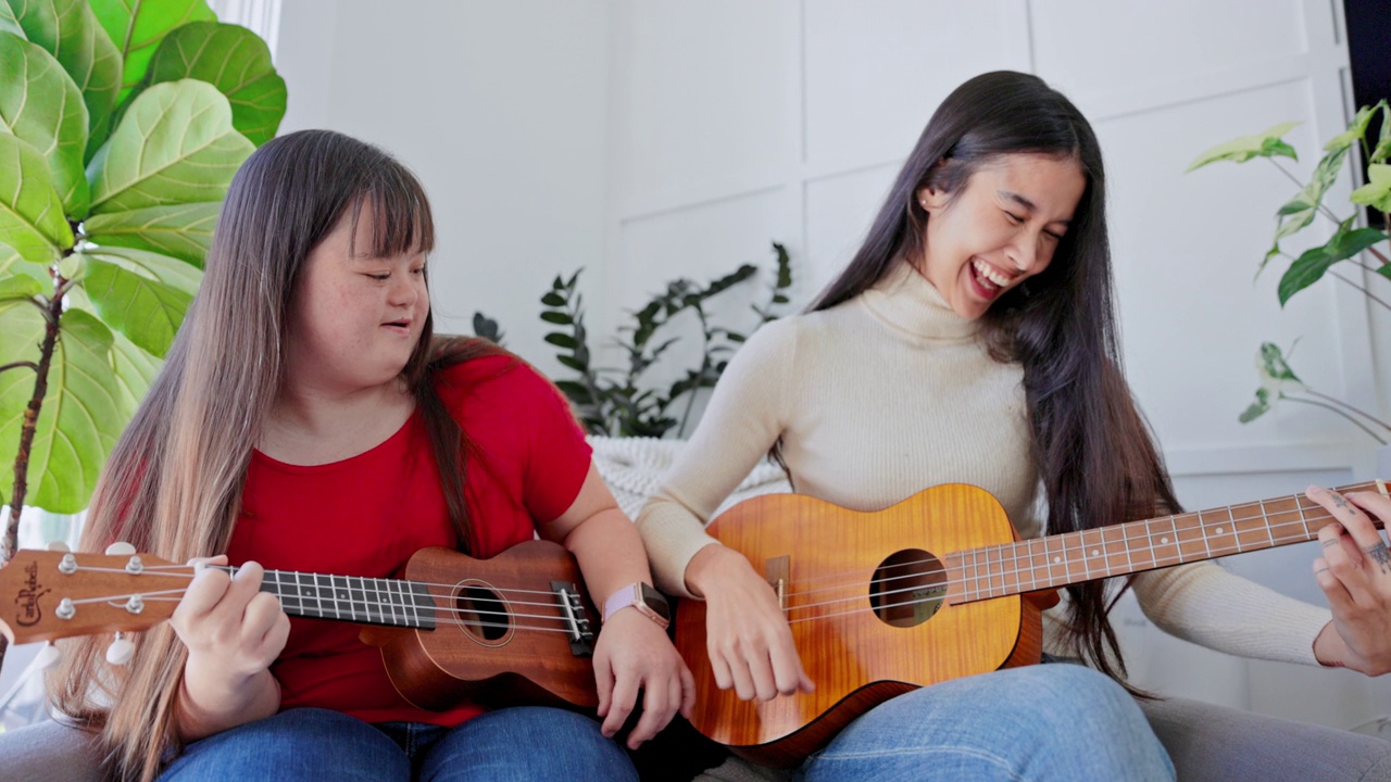 不同的姐妹在一起弹奏尤克里里或吉他。一个患有唐氏综合症。