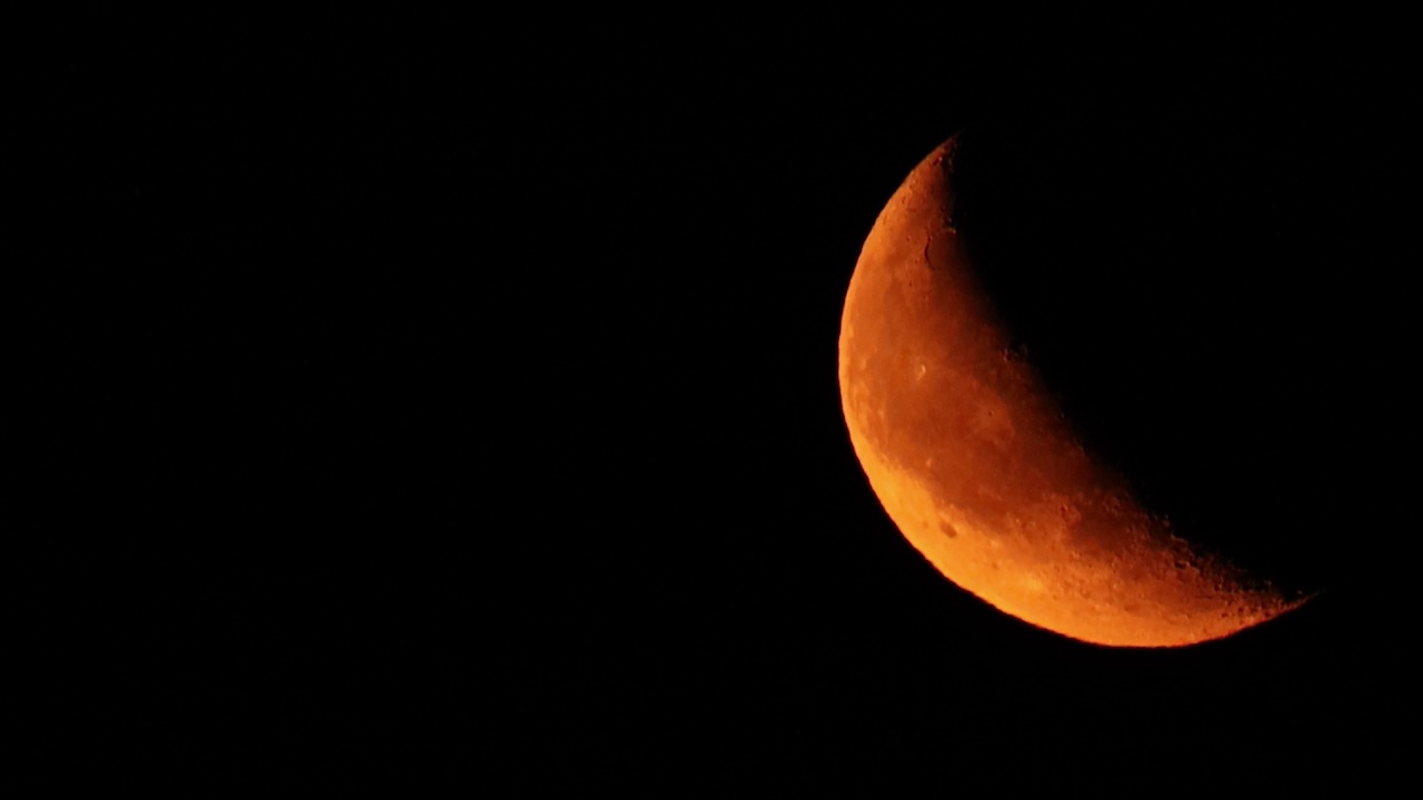 月亮在乌云密布的夜空中升起。夜空自然背景。视频一晚一晚的时间流逝。大的月亮