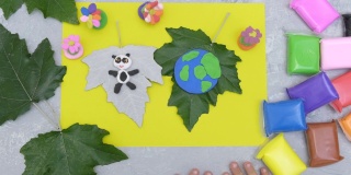 孩子用橡皮泥、纸和天然树叶做卡片。保护环境，拯救我们的地球。生态学的概念。艺术学习与教育的概念