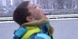 男孩喜欢雪花飘落在他的脸上