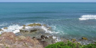 在碧空碧蓝的加勒比海，海浪拍打着岩石