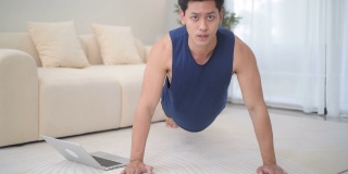 在线体育训练与年轻的亚洲人锻炼在家里使用笔记本电脑