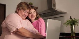 拉丁奶奶和孙女在家里用笔记本电脑