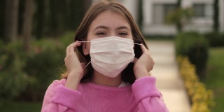 一个拉丁十几岁的女孩在户外移除保护面罩的肖像